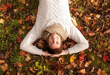 Nainen makaa nurmikolla