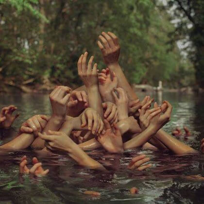 Kädet kurkottavat ylös vedestä