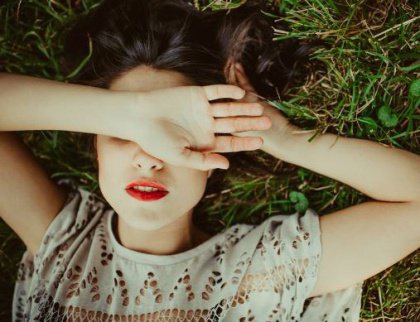 Nainen peittää kasvonsa