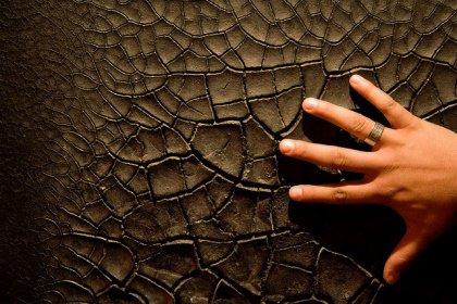 Käsi koskettaa kuivaa pintaa