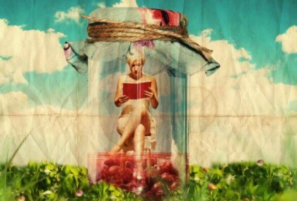 Nainen lukee kirjaa lasipurkin sisässä