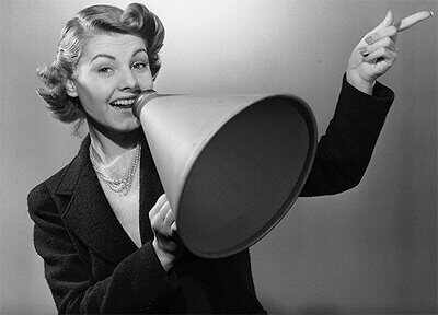 Nainen puhuu megafoniin ja ilmaisee tunteensa