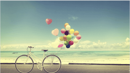 Pyörä ja ilmapallot rannalla