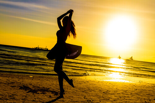 Nainen tanssii rannalla