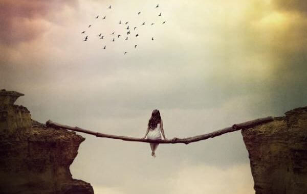 Nainen istuu puusillan päällä