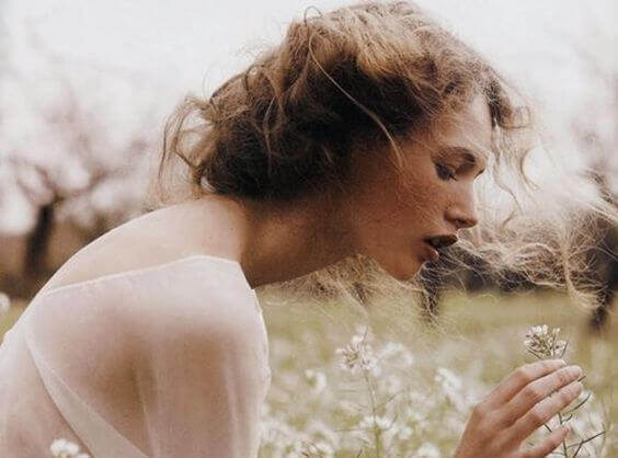 nainen poimii kukkia