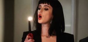 nainen puhaltaa kynttilän