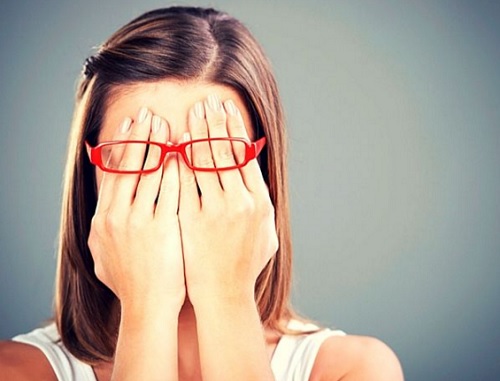 nainen peittää silmänsä