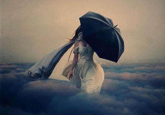 nainen kävelee pilvissä sateenvarjon kanssa