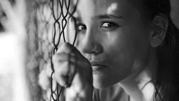 nainen rautalanka-aidan takana