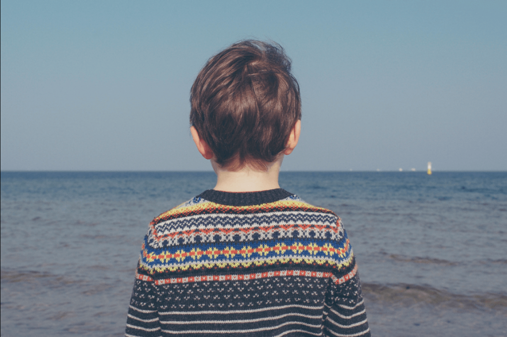 Poika seisoo rannalla yksin