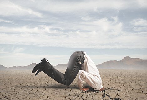 mies on työntänyt päänsä kuivaan maahan