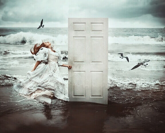 nainen avaa rannalla olevan oven