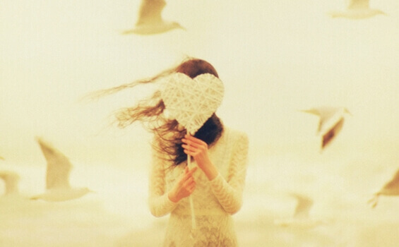 tyttö piilottelee sydämen takana