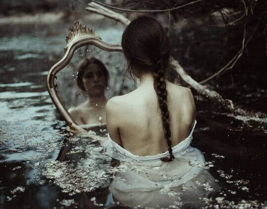 tyttö vedessä katsoo itseään peilistä