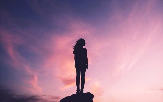 nainen seisoo kalliolla