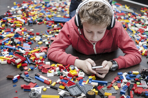 lapsi pelaa puhelimella eikä Legoilla