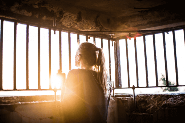 nainen kaltereiden takana