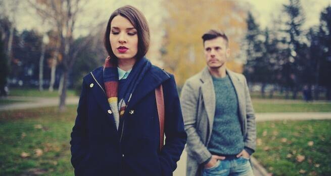 nainen kävelee miehen luota pois