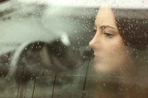 nainen autossa kun ulkona sataa
