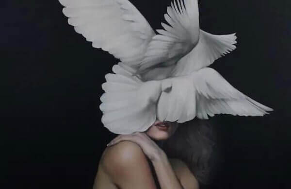 alastoman naisen kasvojen päällä on kyyhkysiä