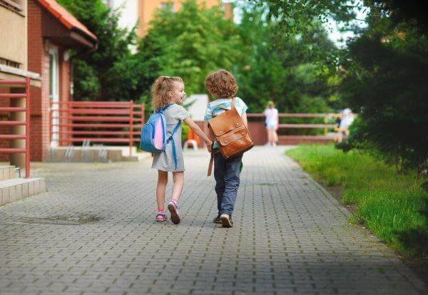 kaksi lasta menee yhdessä kouluun
