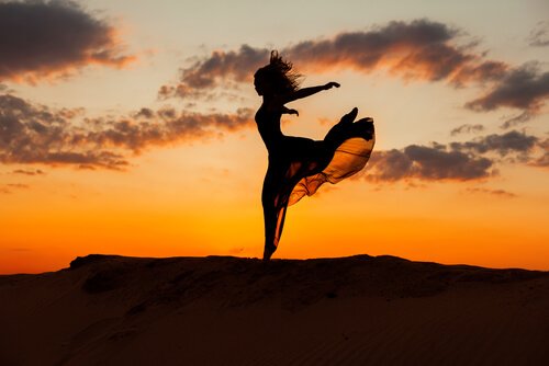 nainen tanssii auringonlaskussa