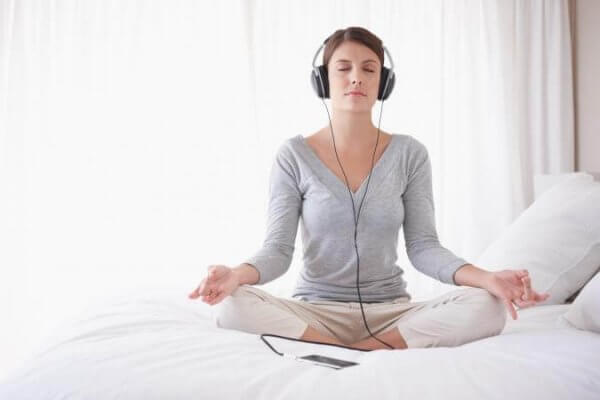 nainen meditoi ja kuuntelee jotain