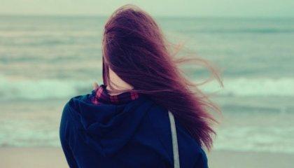 nainen rannalla tuulessa