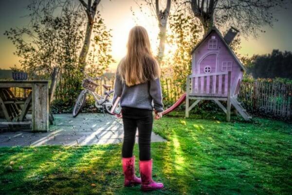 tyttö seisoo puutarhassa