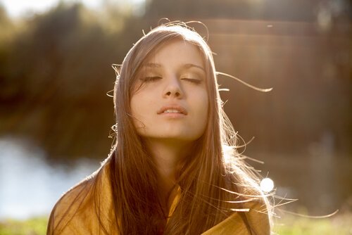 nainen tekee hengitysharjoitusta luonnossa