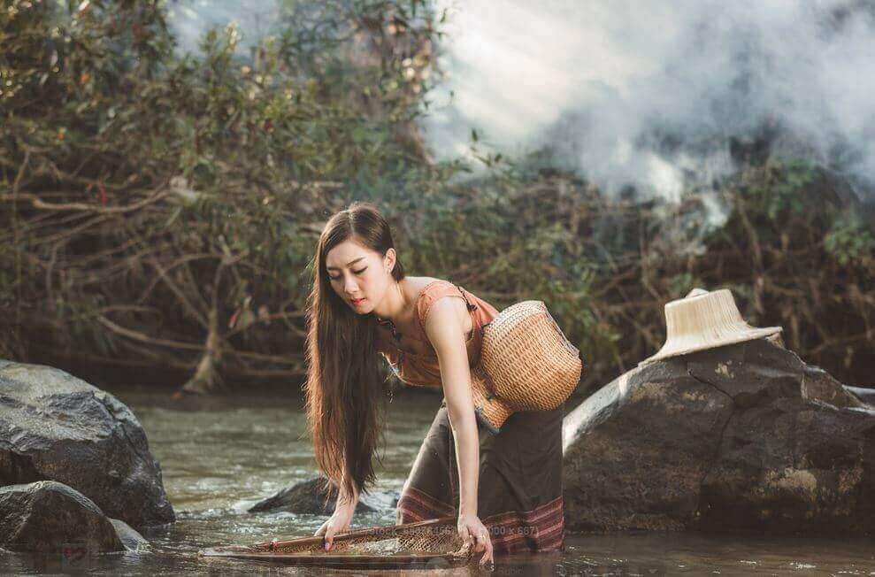 nainen puuhaa joella