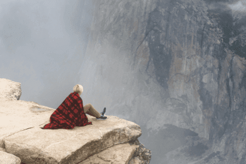 nainen korkealla kalliolla