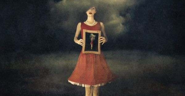 nainen pitelee kuvaa