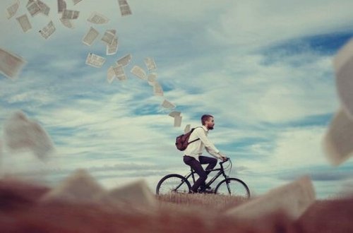 miehen pyöräillessä repusta lentää papereita