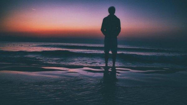 mies seisoo rannalla yksin