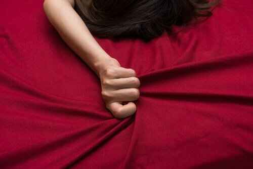 nainen sängyssä punaisissa lakanoissa