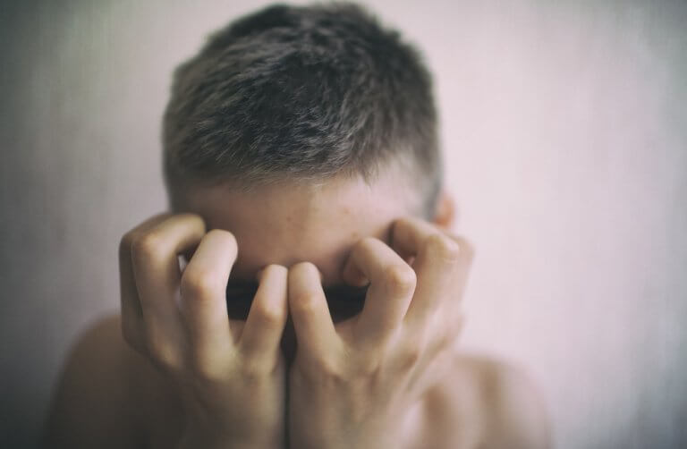 mies raapii kasvojaan