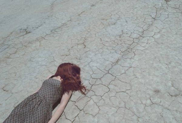 nainen makaa kuivalla maalla