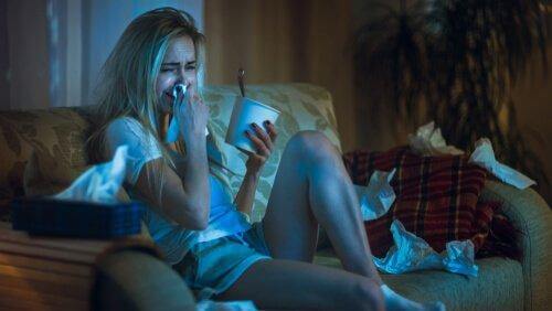 nainen katsoo elokuvaa ja syö jäätelöä