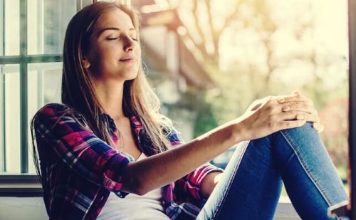 nainen meditoi ikkunan edessä