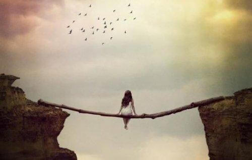 nainen istuu rotkon päällä