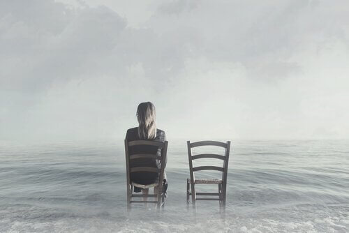 Nainen istuu tuolissa vedessä