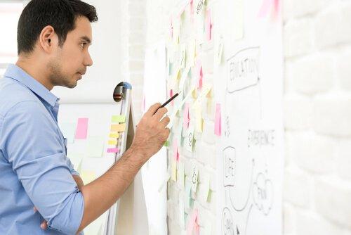 mies piirtää tauluun