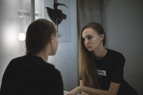 Minäkuva: nainen katsoo peiliin