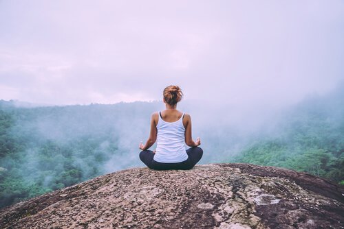 nainen meditoi vuorella