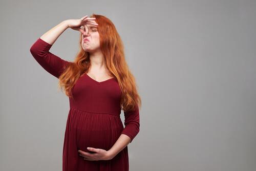 raskaana oleva nainen nyrpistää nenäänsä