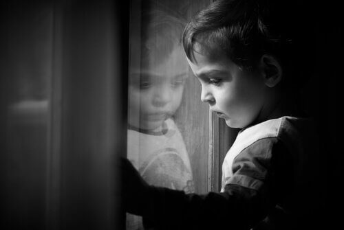 pieni poika katselee ikkunasta ulos