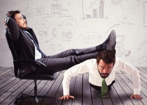 johtaja lepuuttaa jalkojaan työntekijän selän päällä