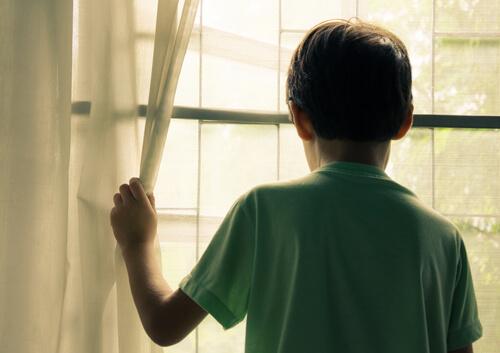 Älyllinen vajavaisuus: lapsi katsoo ulos ikkunasta